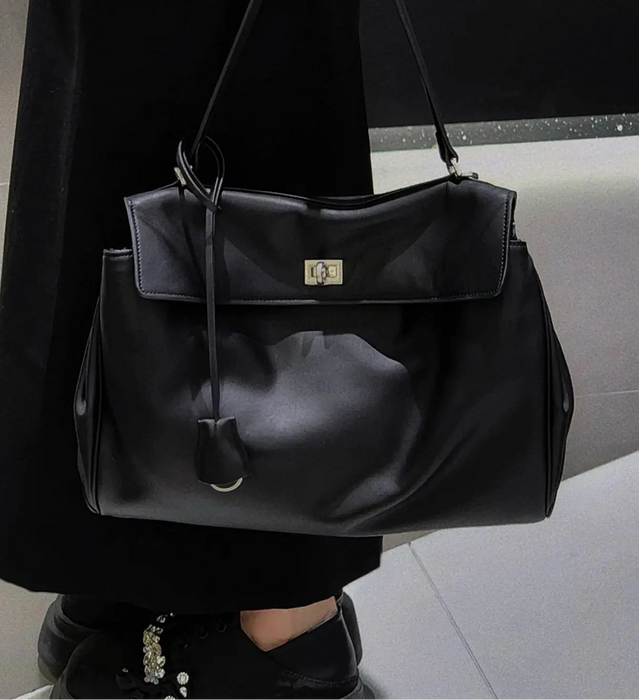 Women’s vegan leather shoulder bag with lock flap closure and soft structure