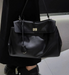 Women’s vegan leather shoulder bag with lock flap closure and soft structure