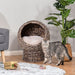 "Wicker elevated cat bed with cozy interior cushion and raised base for indoor comfort"
