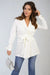 Woman wearing Lexi long sleeve V-neck belted blazer in black, styled with high-waisted trousers